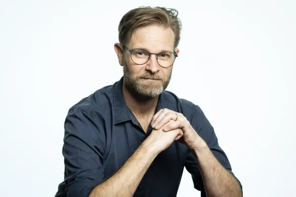 Stephen sitting with his hands crossed.