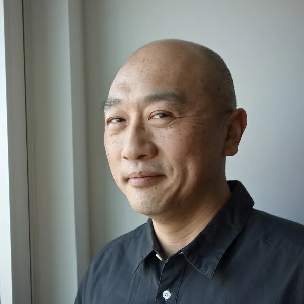 Kevin Toh. Kevin Toh wearing a black button-up shirt, smiling.