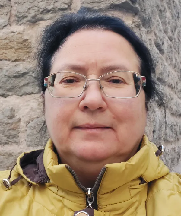 Julia Lajus wearing glasses and a yellow jacket.