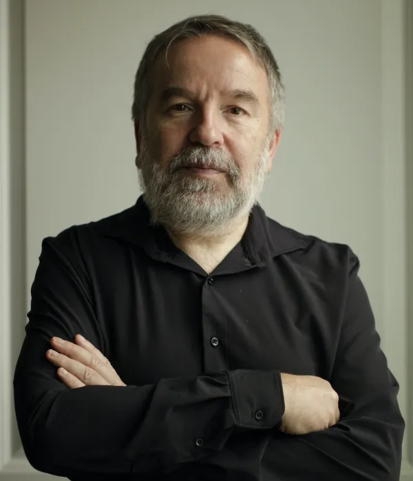 Oleg Lekmanov. Oleg Lekmanov wearing a black button-up, standing hands crossed.