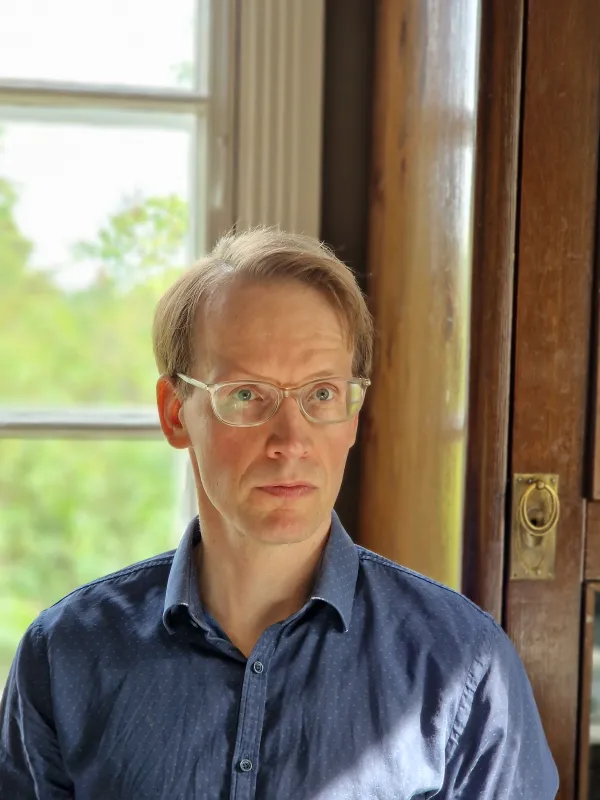 Mika Perälä. Mika Perälä wearing glasses and a blue button-up.