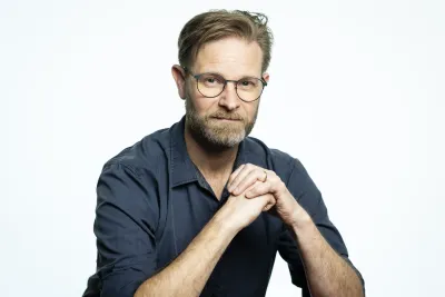 Stephen sitting with his hands crossed.