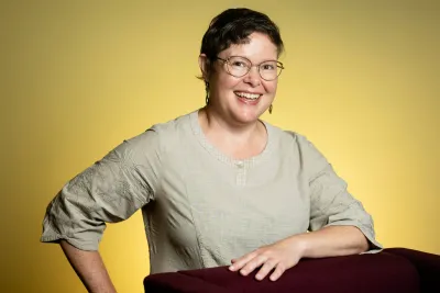 Headshot of Melissa Demian, smiling with one hand on her hip.