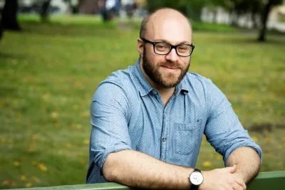 William King wearing glasses and a blue button-up, smiling.