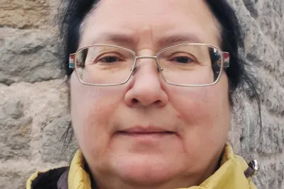 Julia Lajus wearing glasses and a yellow jacket.