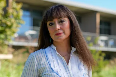 Portrait of Maryam Palizban in the Iméra garden in front of the Maison Neuve building