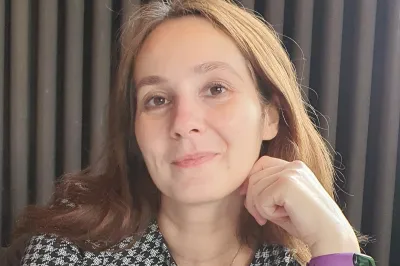 Iuliia Pavlova wearing a houndstooth jacket and smiling.