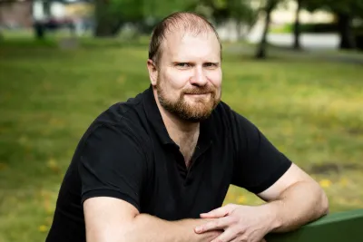 Peeter Selg sits on a park bench, leaning arms against the backrest.