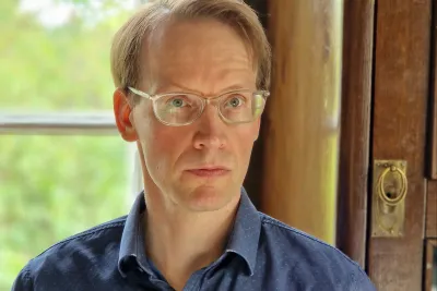 Mika Perälä wearing glasses and a blue button-up.