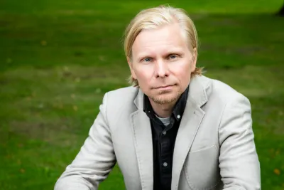 Tero Toivanen sitting outside, wearing a light gray blazer.