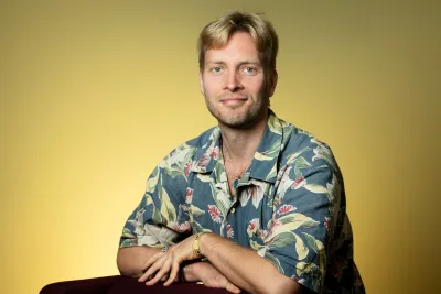Patrik Wikman. Photo by V. Somerpuro. Patrik Wikman wearing a colorful shirt, leaning against a chair.